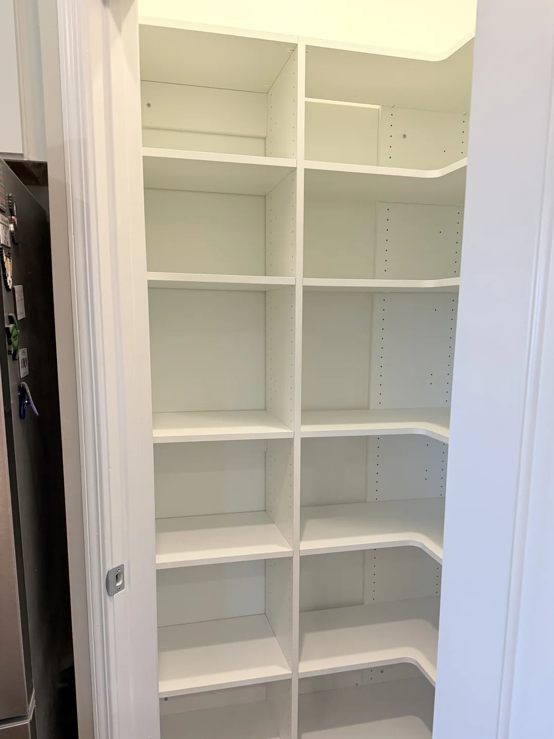 After: custom floor-based pantry with adjustable wood shelves and curved corner shelving